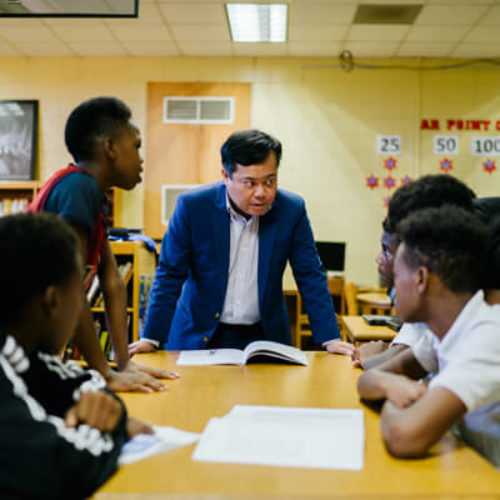 Older man sternly mentoring teenage boys